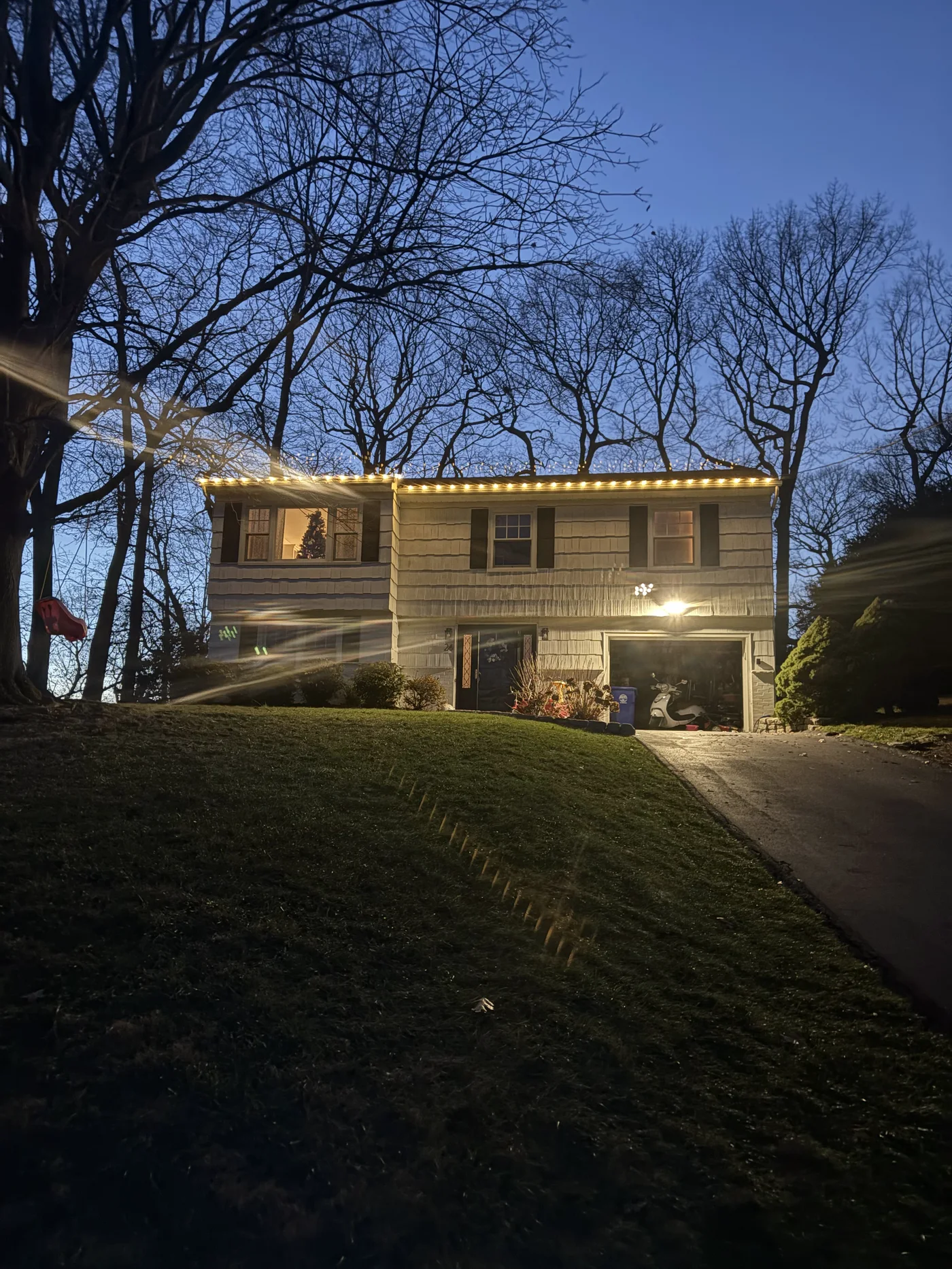 Roofline lighting at dusk, seen from the driveway