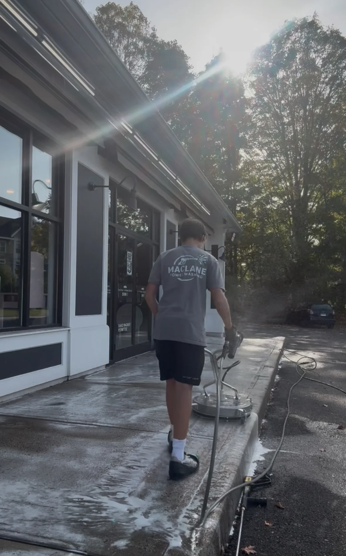 Technician running a surface cleaner across a stone patio